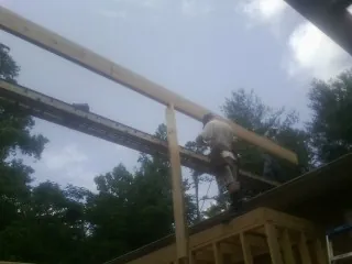 Carpenter setting a ridge beam over a new addition frame — Ice Dam Removal by Roofing Brothers in Bergenfield