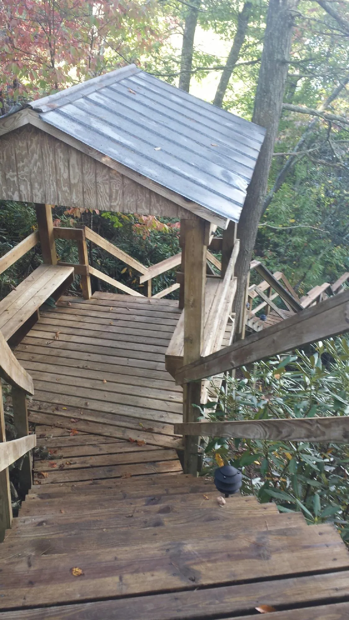 Metal roofed shelter over wooden steps on a wooded walkway — Skylight Repair & Installation work by our crew in Bergenfield