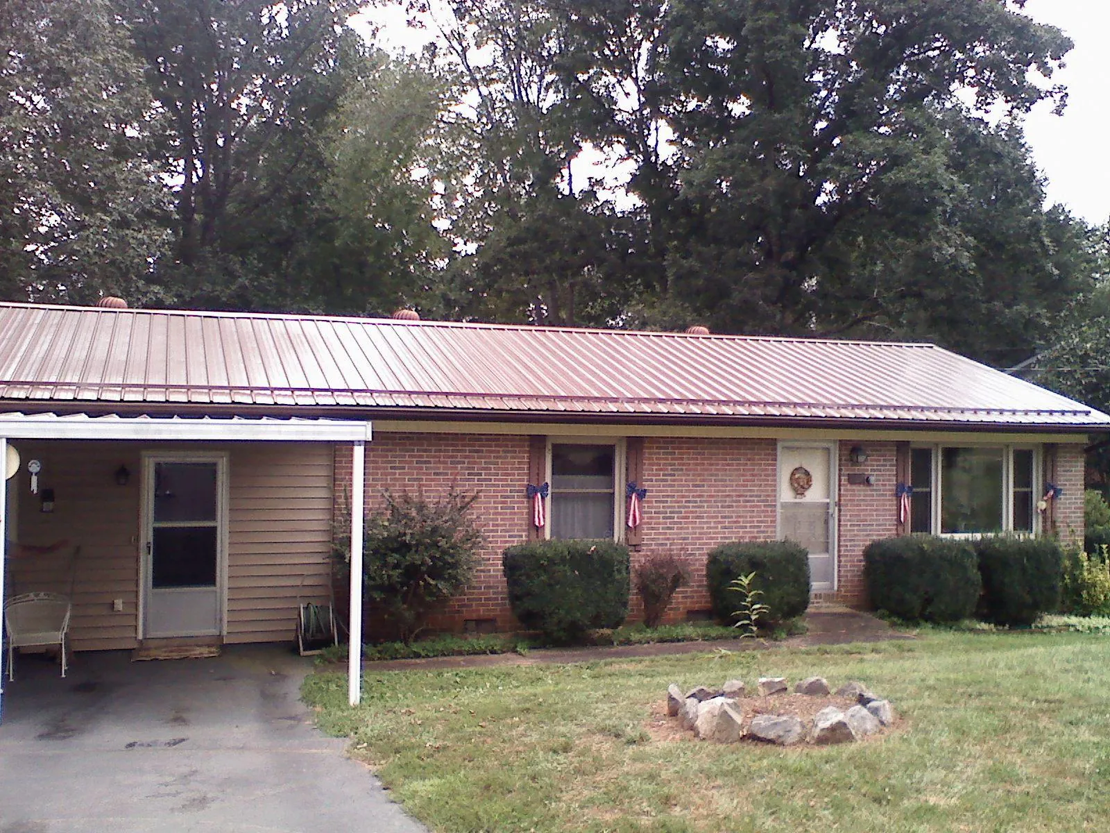 Bronze metal roof and carport on a brick ranch home — Roof Repair work by our crew in Bergenfield